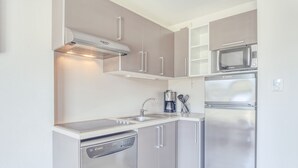 Una cocina moderna con electrodomésticos de acero inoxidable, incluyendo lavavajillas, microondas y refrigerador.