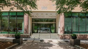 A building entrance with a sign reading '300' and 'Peachtree Towers'.