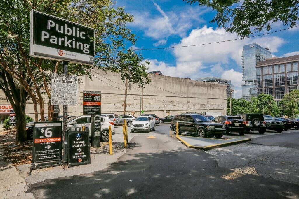 Un parking public avec un panneau indiquant un tarif de 6 dollars pour une durée maximale d’une heure.