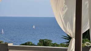 A balcony with a view of the sea, featuring two sailboats and lush greenery. - Villa (Torre Vado)