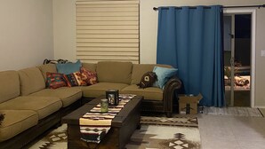 A living room with a sofa, coffee table, and a ceiling fan. - Quit friendly Neighborhood  (Anthem)