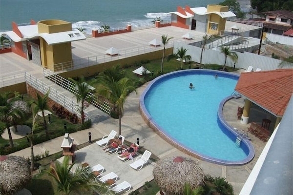 view of resort facilities from the deck. Pool, lounge area, covered area by pool