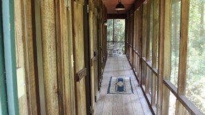A wooden corridor with large windows and a hanging light fixture.