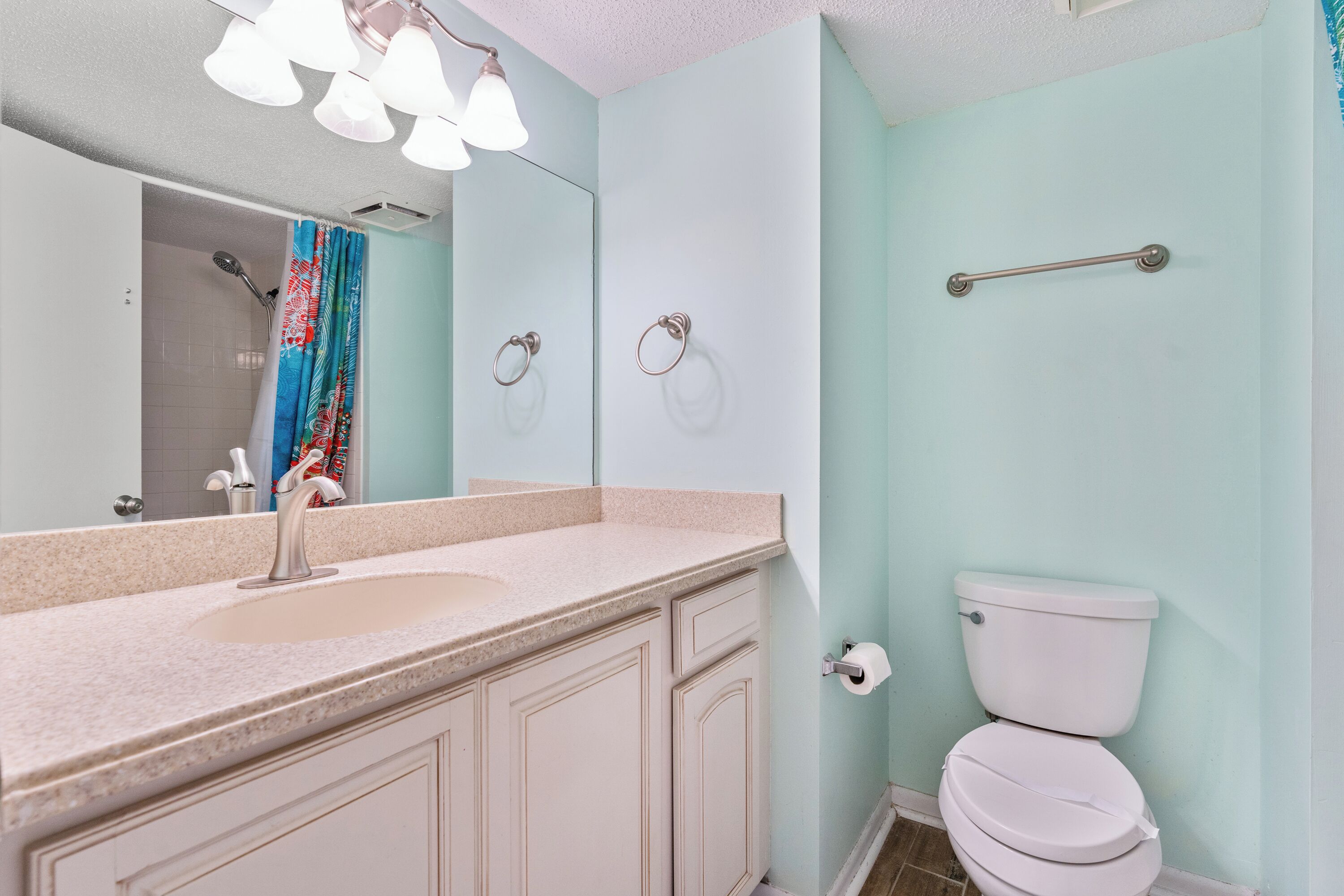Ein Badezimmer mit Waschbecken, Spiegel, Toilette und Dusche.