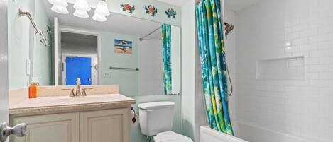A bathroom with a toilet, sink, and shower.