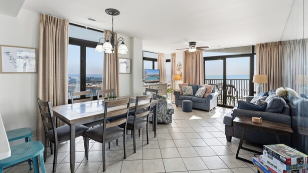 Ein großzügiger Wohnbereich mit Esstisch, Sofas und einem Balkon mit Blick.