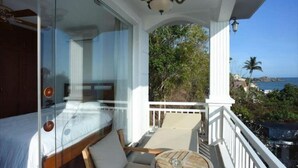 A balcony with a bed, a chair, and a table. - SV Boutique Resort (Vung Tau)
