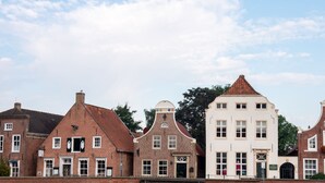 Una hilera de edificios de estilo europeo tradicional, con características arquitectónicas notables, incluyendo tejados a dos aguas y fachadas de ladrillo.