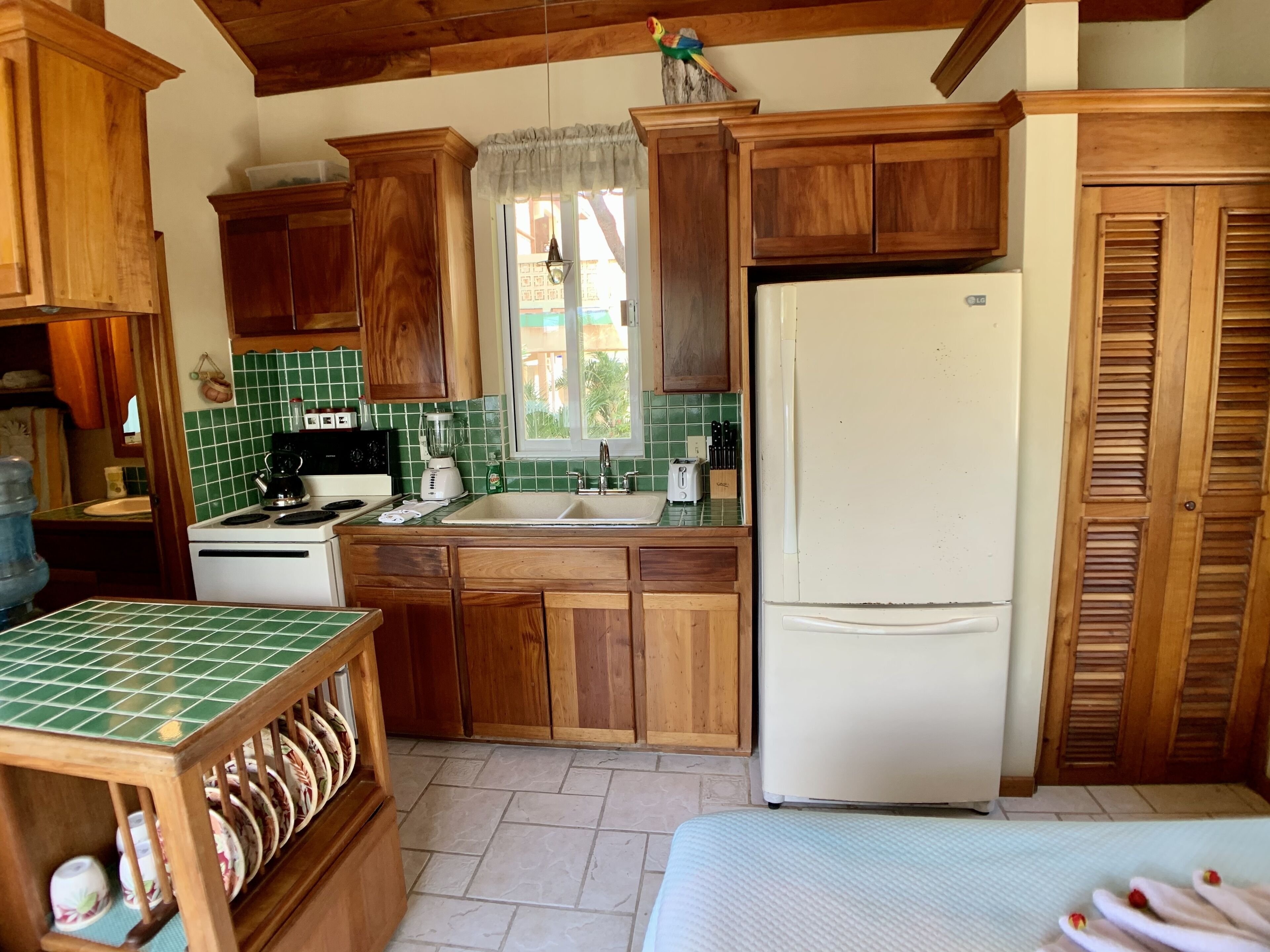 Une cuisine avec des meubles de rangement en bois, un réfrigérateur blanc, une cuisinière et un évier.