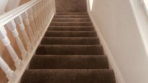 A staircase with white balusters and carpeted steps leading to a landing. - Inviting 5-bed House in Eastbourne (Eastbourne)