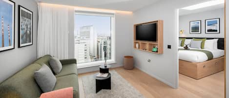 Un dormitorio moderno con vistas a la ciudad, un ventanal grande, una cama con estructura de madera y un televisor montado en la pared.