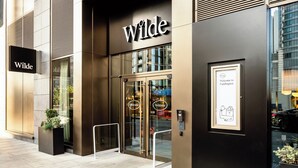A modern building with a 'Wilde' sign above the entrance. - Wilde Aparthotels, London, Paddington (London)