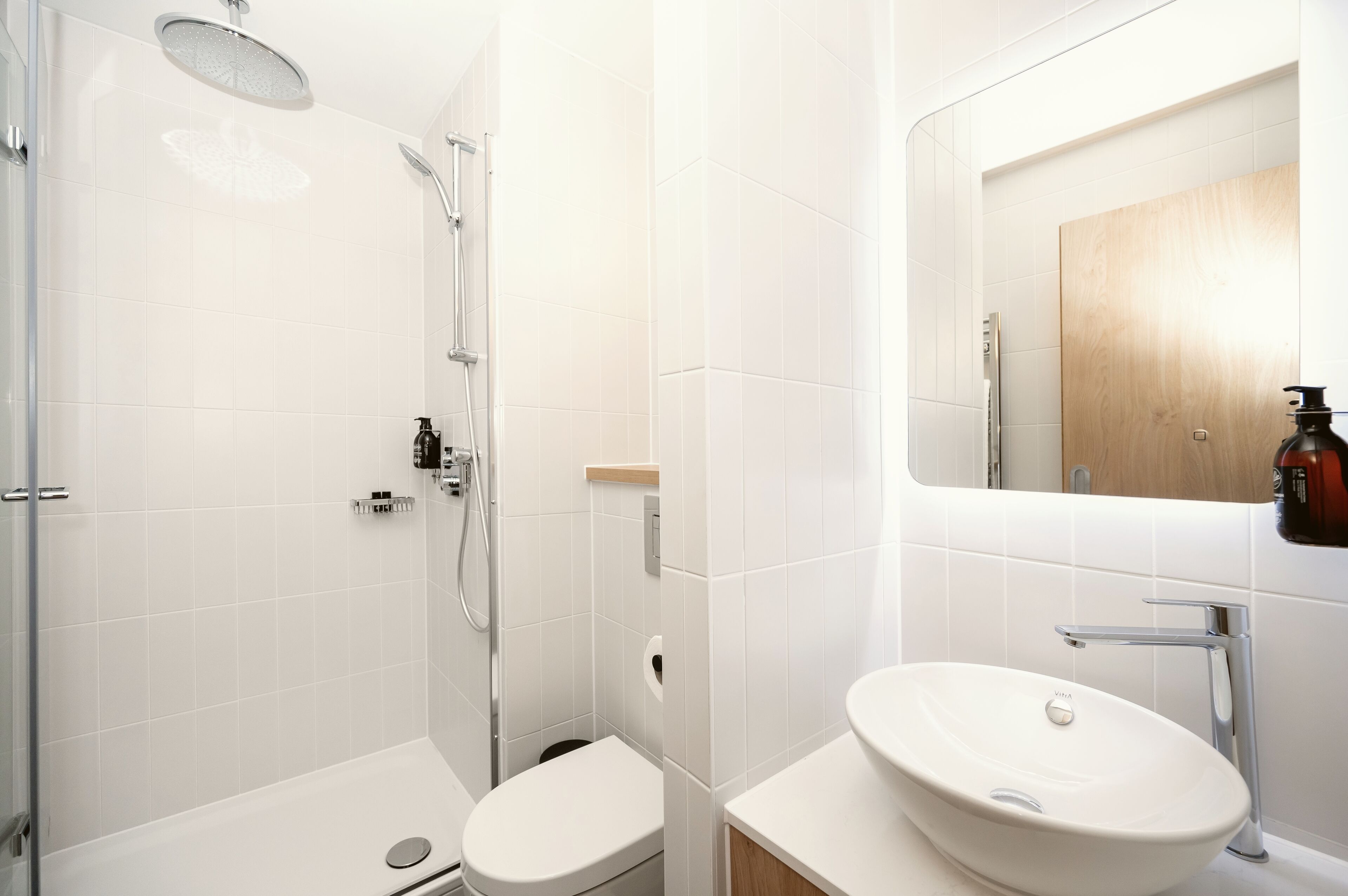 A modern bathroom with a shower, toilet, and sink.