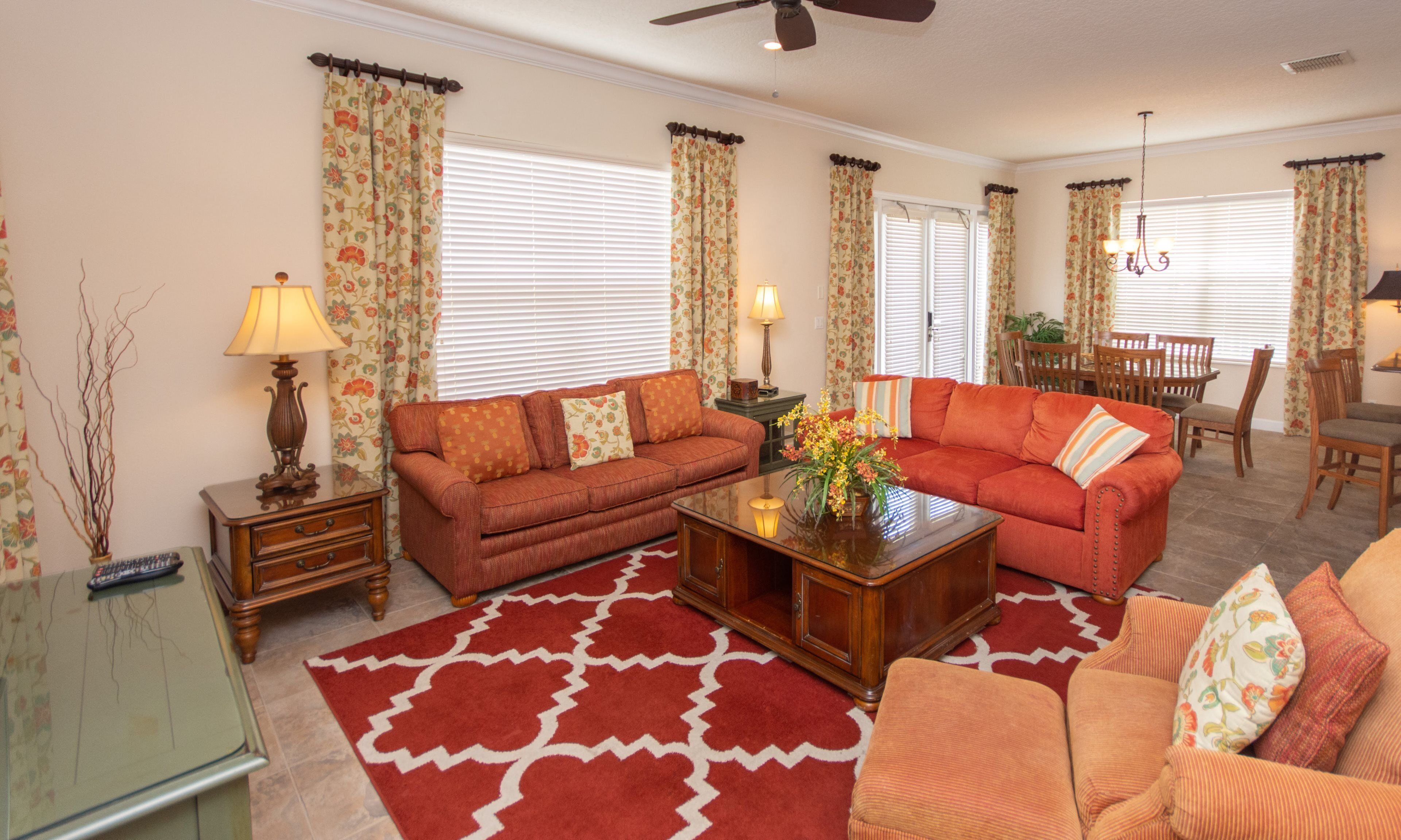 A living room with two sofas, a coffee table, and a dining area with chairs and a table.