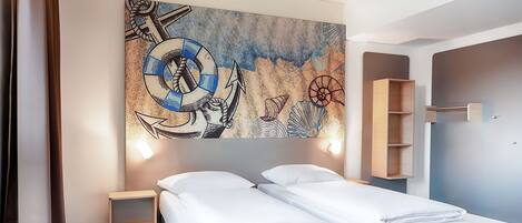 Une chambre d’hôtel avec deux lits, un bureau, une chaise, un grand tableau abstrait accroché au mur et une armoire en bois.