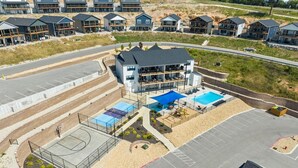 A residential complex with multiple houses, a basketball court, and a swimming pool. - Modern Lakeview with All Ensuites, Entertainment Room, & Outdoor Fire Features (Branson)