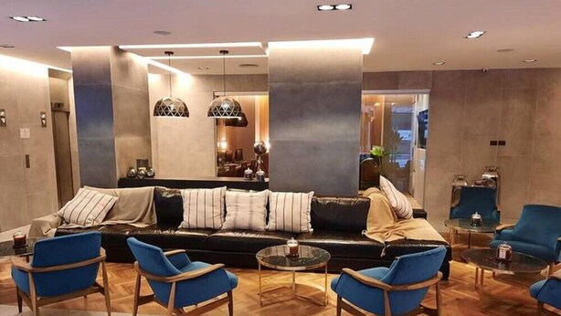 A modern hotel lobby with a sofa, blue armchairs, and a coffee table. - Impeccable Junior Suite with Gym in Buenos Aires (Buenos Aires)