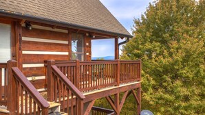 Une cabane en bois avec un balcon, une antenne parabolique et une vue sur les montagnes.