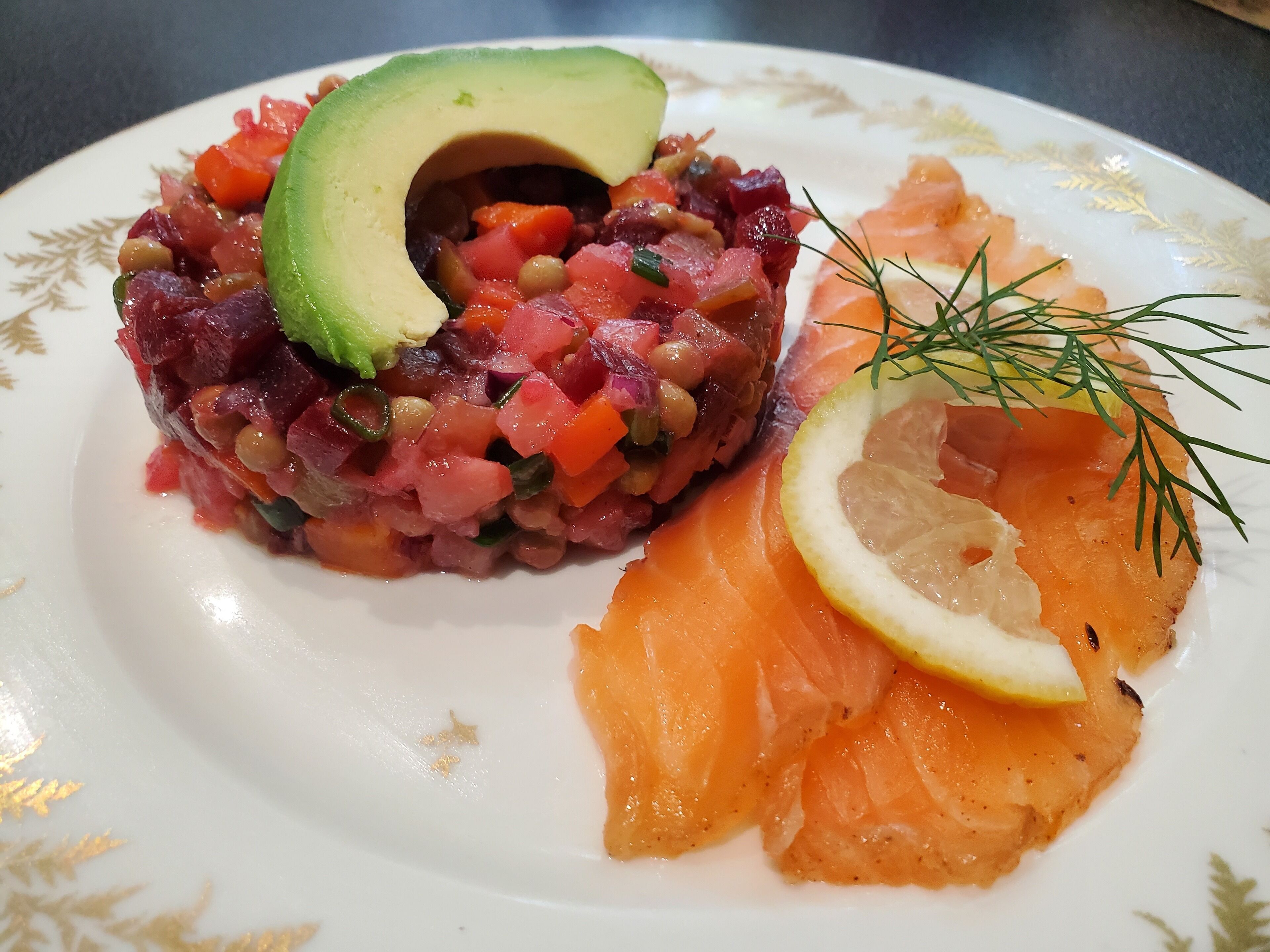 Un plato con ensalada de tartare, salmón ahumado y aguacate.