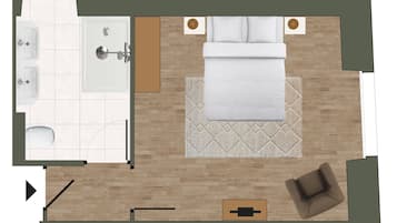 A hotel room layout with a bed, a sitting area, a bathroom, and a small table.