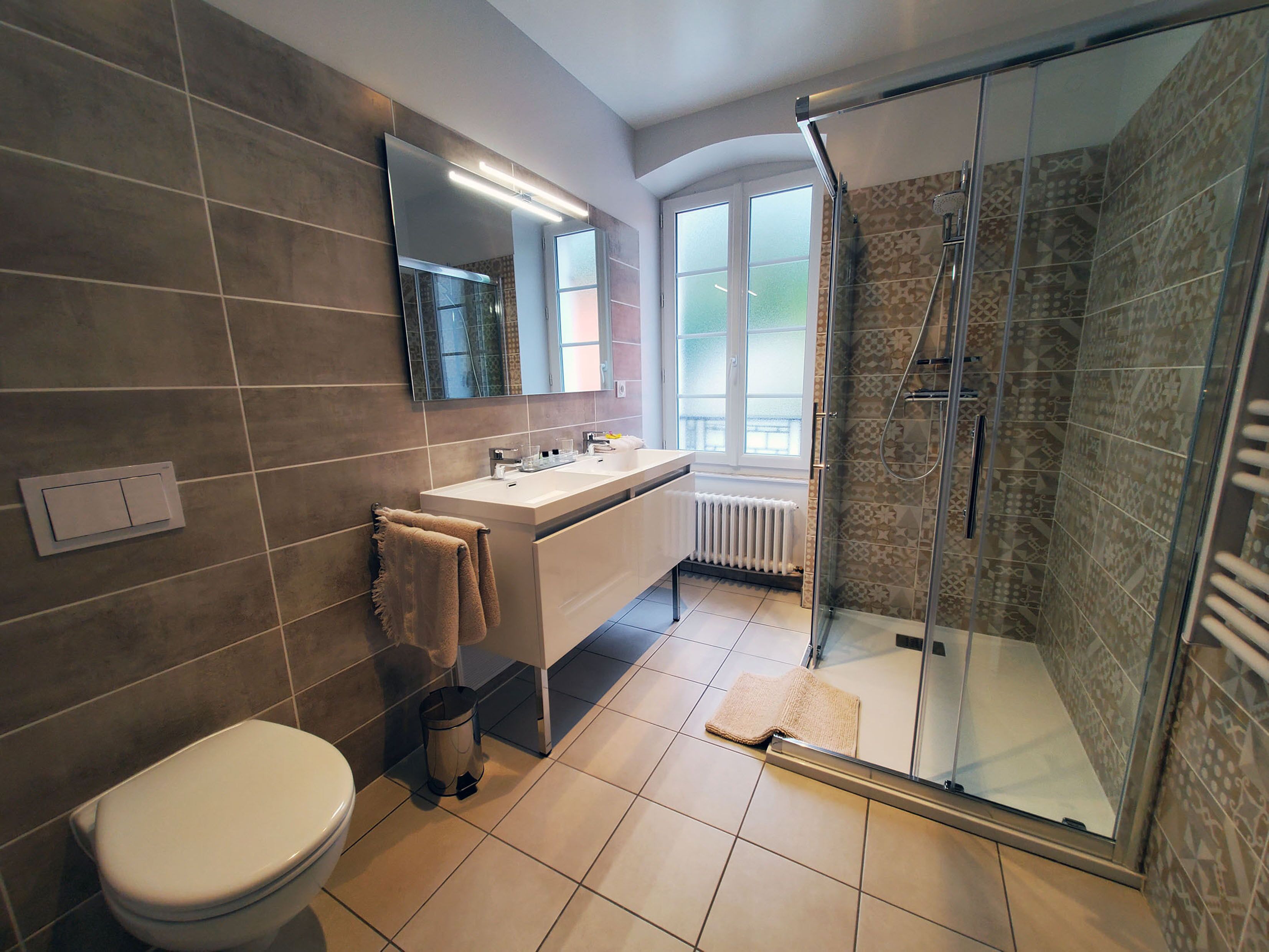 A modern bathroom with a toilet, sink, and shower.