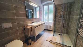 A modern bathroom with a toilet, sink, and shower.