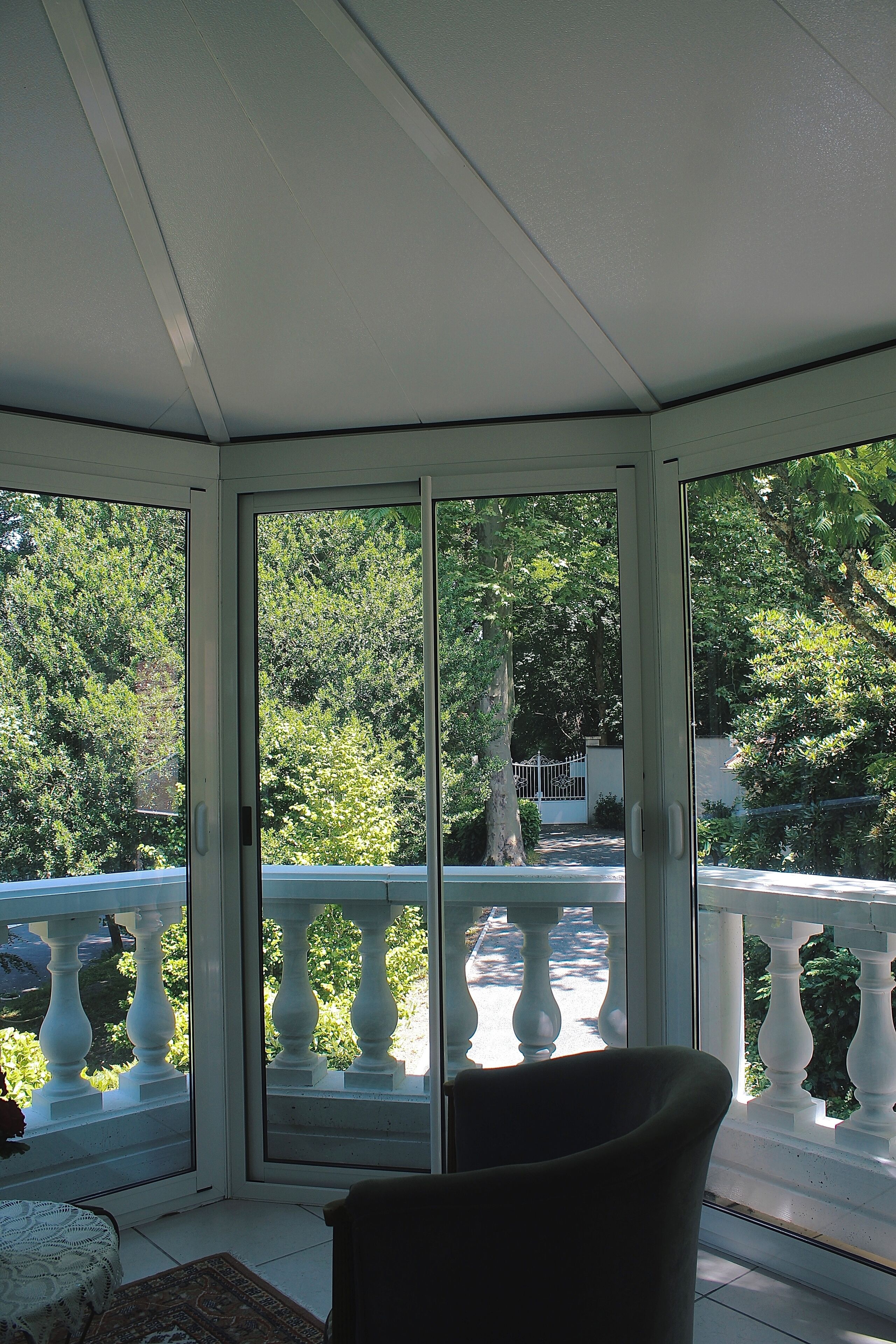 A room with a view of a balcony and trees.