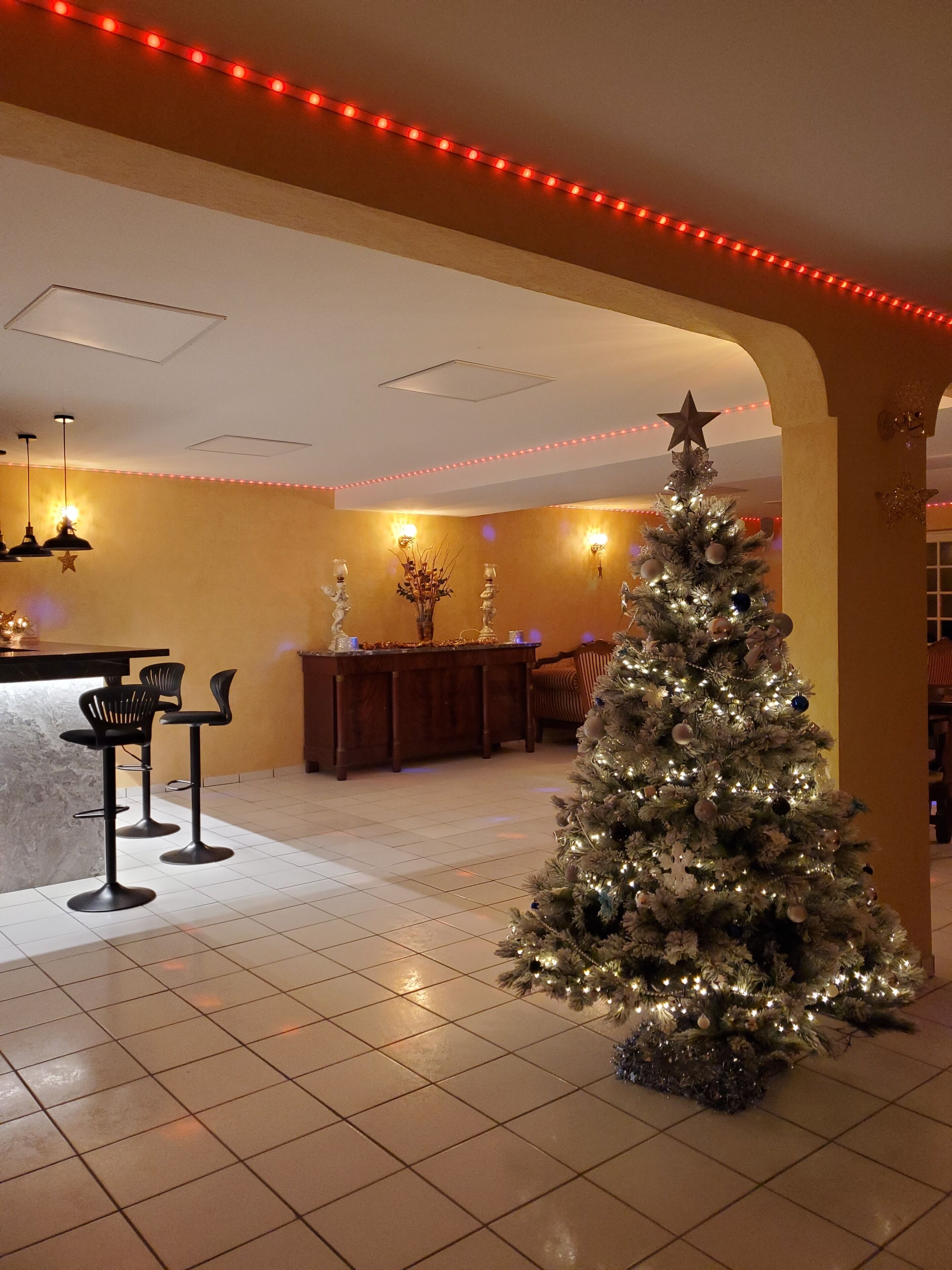 Un hall d’entrée spacieux, agrémenté d’un grand sapin de Noël, d’un bar et d’un espace salon.