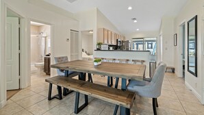 Eine moderne Küche mit Holzausstattung, einer zentralen Kochinsel und einem Essbereich mit Holztisch und Bänken.