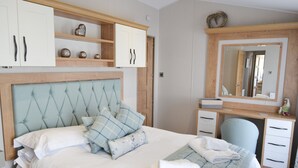 A bedroom with a large bed, a desk, and a wardrobe. - Herdwick Lodge. Percy Woods (Morpeth)