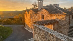 A stone building with a traditional design, featuring a stone pathway leading to the entrance. - Charming cottage "La Caussenarde (Saint-Beauzély)