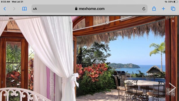A bedroom with a view of the sea, a balcony with outdoor furniture, and a thatched roof structure. - Great ocean views, walking distance to town/ beach, heated pool, family friendly (Sayulita)