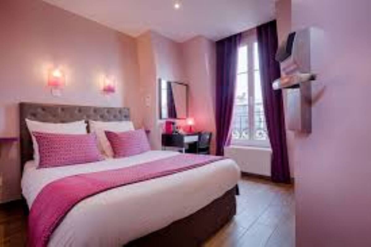 A bedroom with a large bed, a nightstand, a dresser, a mirror, and a window with curtains.