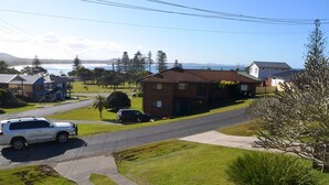 Un quartier résidentiel avec des maisons, une rue et une voiture garée au bord du trottoir.