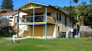 Une maison à deux étages avec un balcon, un garage et une cour clôturée.