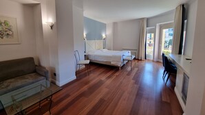A bedroom with a bed, a desk, a chair, a sofa, and a window with curtains. - Canali (Rapallo)