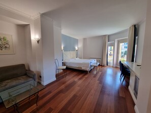 A bedroom with a bed, a desk, a chair, a sofa, and a window with curtains. - Canali (Rapallo)
