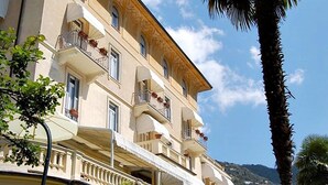 A multi-story hotel with balconies, outdoor seating, and a view of the sea. - Canali (Rapallo)