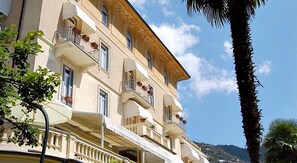 A multi-story hotel with balconies, outdoor seating, and a view of the sea. - Canali (Rapallo)