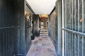 Staircase leads to a central landing in a functional corridor with a tiled floor.