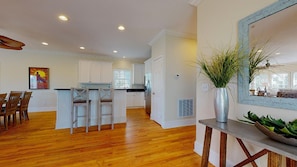 Enjoy meals in the kitchen with a central island and dining area, featuring a large mirror and comfortable seating.