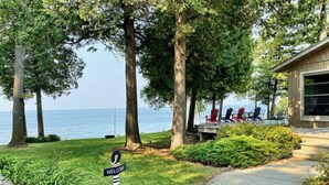 Une propriété située en bord de mer, dotée d’une terrasse avec vue sur l’océan, d’un panneau d’accueil et d’un espace salon extérieur.