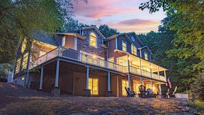 Ein großes, zweistöckiges Haus mit einer Veranda und vielen Fenstern.