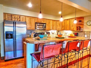 Enjoy cooking in this kitchen with a refrigerator, microwave, and bar area.