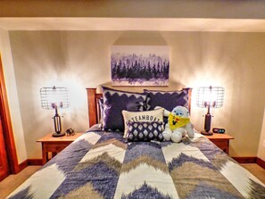 Cozy retreat with a large bed, bedside tables, and a wall-mounted artwork.