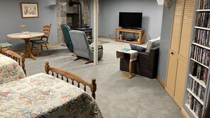 A cozy living room with a fireplace, a television, a bookshelf, and comfortable seating.