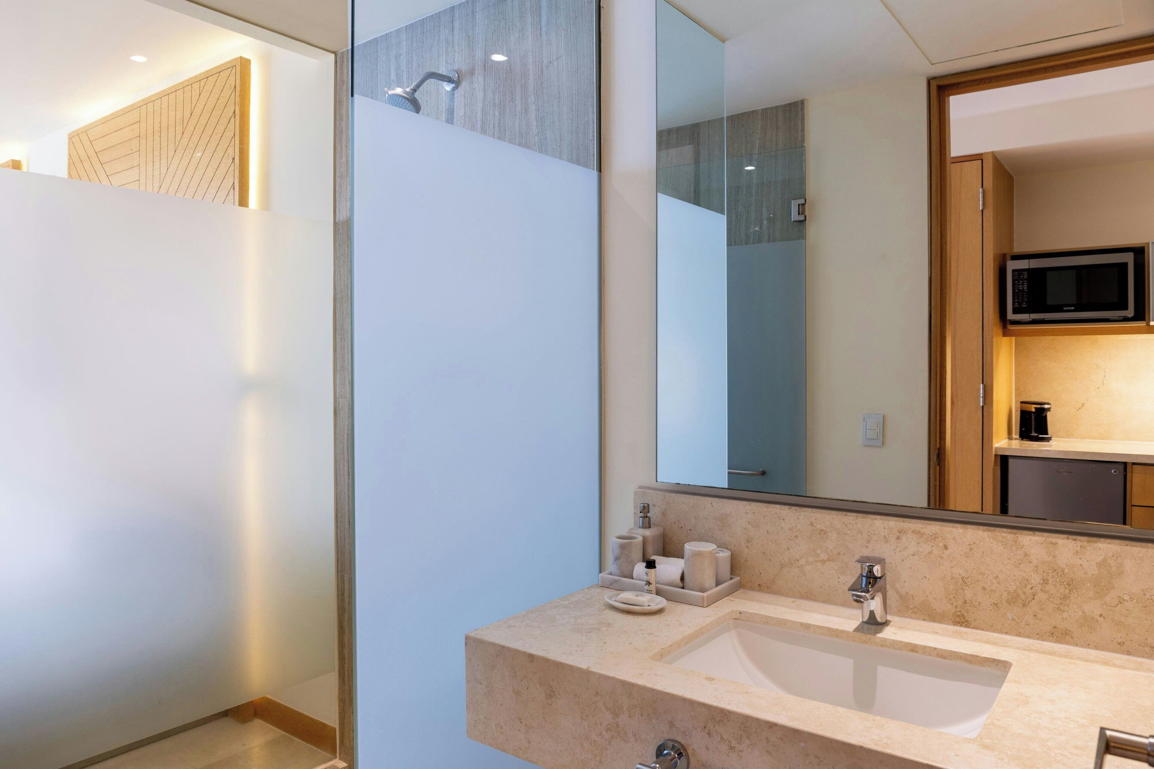 Un baño moderno con un espejo grande, dos lavamanos y una ducha.