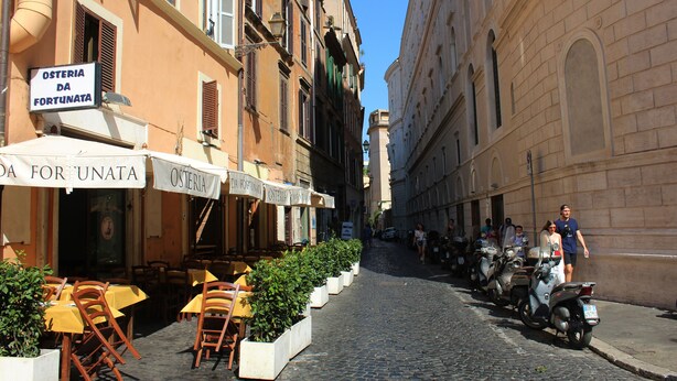 A cobblestone street lined with outdoor seating and a restaurant named "Osteria da Fortuna." - Abode of the Acetari in Campo de 'Fiori (Roma)