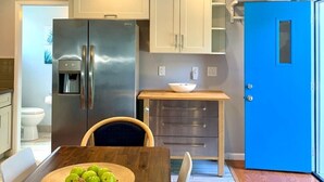A modern kitchen with stainless steel appliances, wooden cabinets, and a blue door. - Newly remodeled spacious 2bed/2bath with backyard in Willow Glen (San Jose)