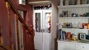 Una escalera con barandillas de madera que conduce a una puerta blanca con un vitral.